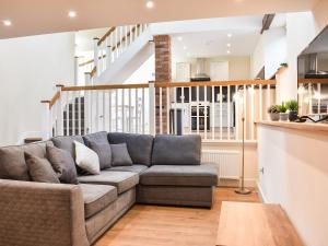 a living room with a couch and a staircase at Tarn Cottage - Uk42803 in Mungrisdale