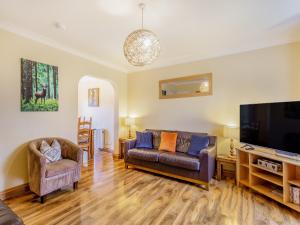 a living room with a couch and a flat screen tv at Cairnie View in Aviemore