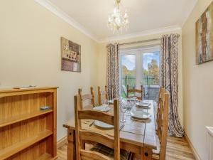 a dining room with a table and chairs and a window at Cairnie View in Aviemore