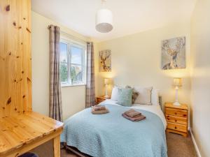 a bedroom with a bed and a window at Cairnie View in Aviemore