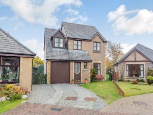 a house with a driveway and a garage at Cairnie View in Aviemore