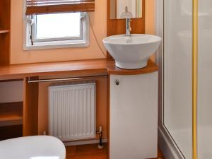 a bathroom with a sink and a window at Inglenook Lodge in Lamplugh