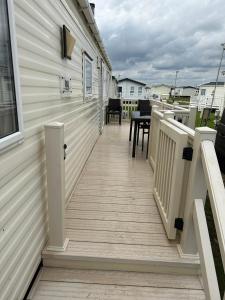 a deck with a table and chairs on a house at Camber Vacations in Camber