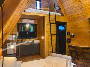 a kitchen and a loft with a ladder in a room at Cabana Nova Petrópolis in Nova Petrópolis
