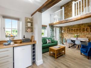 eine Küche und ein Wohnzimmer mit einem grünen Sofa in der Unterkunft Cherry Cottage - Uk46357 in Grantley