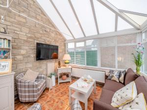 a conservatory living room with a stone wall at The Roddy House in West Bay
