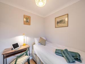 a bedroom with a bed and a desk with a laptop at The Roddy House in West Bay