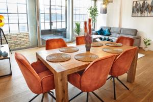 tavolo da pranzo in legno con sedie arancioni di IDEE Living Industrial style- Apartment- Balkon a Neustadt an der Weinstraße