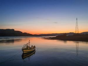 a small boat in the water at sunset at Muir-lan in Ellanbeich