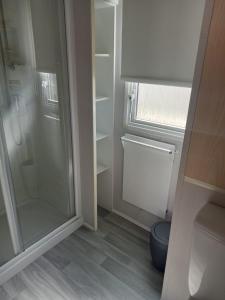 a small bathroom with a shower and a toilet at Camber Vacations in Camber