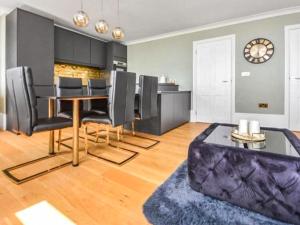 a dining room with a table and black chairs at Wellington Views in Ramsgate