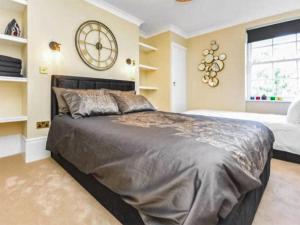 a bedroom with a large bed and a clock on the wall at Wellington Views in Ramsgate