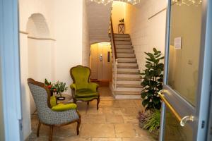 een hal met 2 stoelen, een tafel en een trap bij CASA ALMIKA PRINCIPE AMEDEO in Bari