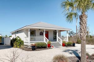 a small white house with a palm tree at Salty Dawgs Jr in Mexico Beach