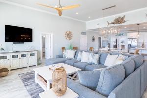 a living room with a blue couch and a tv at Waves of Grace in Dauphin Island