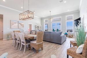 a dining room and living room with a couch and a table at Waves of Grace in Dauphin Island