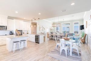 a kitchen and living room with a table and chairs at Waves of Grace in Dauphin Island +77 photos