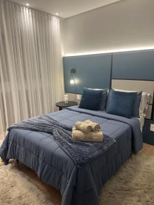 Un dormitorio con una cama azul con una toalla. en Canela Cantinho dos Sonhos, en Canela