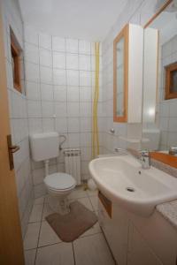 a white bathroom with a sink and a toilet at Maison du Bonheur in Sarajevo