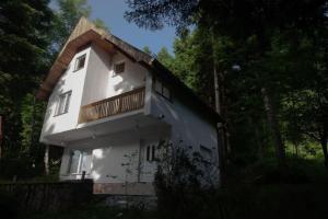 Casa blanca con balcón en la parte superior. en Maison du Bonheur, en Sarajevo