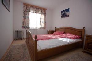 sypialnia z łóżkiem z czerwoną pościelą i oknem w obiekcie Maison du Bonheur w Sarajewie