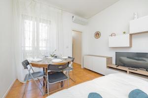 a white room with a dining room table and a tv at Niguarda Hospital M5 Lilla 10 Home Away WiFi AC in Milan