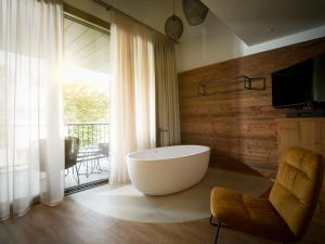 a large bathroom with a tub and a balcony at Hotel Bütgenbacher Hof in Butgenbach