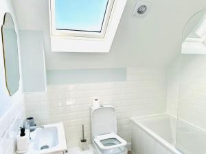 a bathroom with a toilet and a sink and a window at Dover luxury apartments, near Ferry in Dover