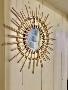 a large wooden sunburst mirror hanging on a wall at Appartement centrum Delft in Delft