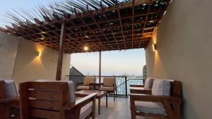 a restaurant with wooden tables and chairs on a balcony at درة العروس فيلا بشاطئ رملي خاص in Durat  Alarous