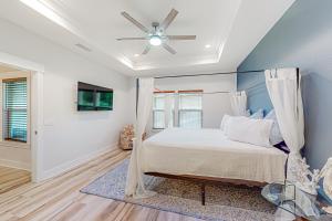 um quarto com uma cama e uma ventoinha de tecto em Driftwood Dreams em Panama City Beach