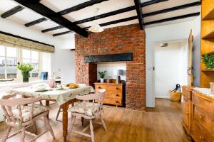 a kitchen with a brick wall and a table and chairs at Yew Tree Cottage in Ayton