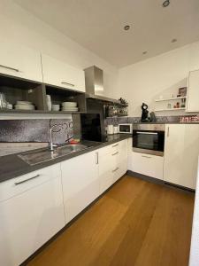 a kitchen with white cabinets and a sink at Ferienwohnung Lieblingsplatzl in Wenns