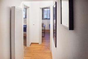 un corridoio con pareti bianche e uno specchio a parete di IDEE Living Industrial style- Apartment- Balkon a Neustadt an der Weinstraße