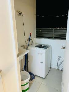 uma máquina de lavar e secar roupa numa casa de banho com uma janela em Departamento Equipado em Copiapó