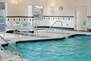 a pool in a hotel with chairs and a table at Fairfield Inn and Suites by Marriott Harrisonburg in Harrisonburg