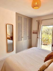 1 dormitorio con 1 cama grande y espejo en Can Yuca I, en Santanyí