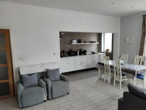 a kitchen and dining room with a table and chairs at Appartement spacieux avec parking et terrasse in De Panne