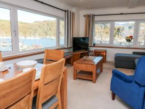 a living room with a table and chairs and a television at Leeward in Dartmouth