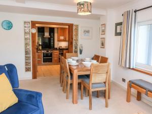 a kitchen and dining room with a table and chairs at Leeward in Dartmouth +8 photos