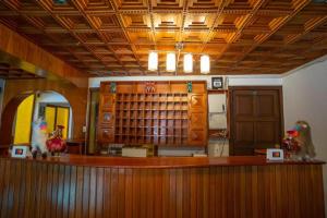 a library with a wooden counter with two figurines on it at Hotel Romero Cusco in Cusco
