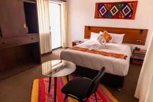 a hotel room with a bed and a glass table at Hotel Romero Cusco in Cusco