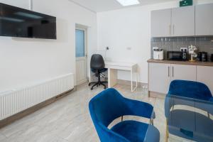 a kitchen with two blue chairs and a desk at Kunda House Coventry Road in Birmingham