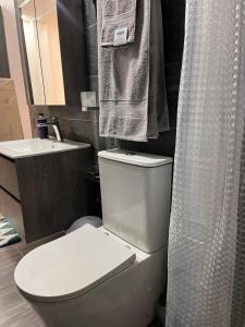 a bathroom with a white toilet and a sink at NBA PLUSH APARTMENT - NSROMA in Accra