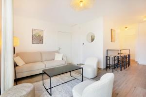 uma sala de estar com um sofá e uma mesa em La Résidence Alpha Viroflay 301 - Duplex 2 chambres - 6 pers em Viroflay