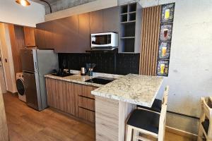 a kitchen with a refrigerator and a counter top at Departamento Compartido Centro Monterrey - Barrio W in Monterrey