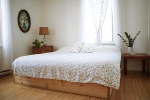 a bedroom with a bed with a white blanket and a window at Auberge Incroyable in Saint Adrien +32 photos