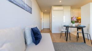 a living room with a white couch and a table at Nice Circunvalação Studio II By Unique Hosts in Senhora da Hora