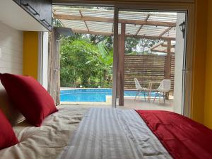 1 dormitorio con cama y piscina en Subtropica Premium Suites - Mindo, en Mindo