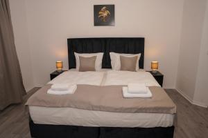 a bedroom with a large bed with two night stands at GN Hotel Furpach in Neunkirchen